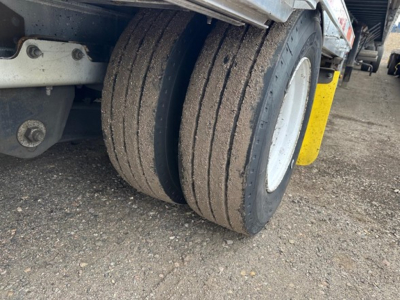 Trailer dual-tire setup with dirt on tires, rear view of 2016 Trail King all aluminum drop deck trailer showing dual wheels and mudguard.
