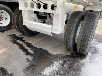 Dump trailer rear axle and suspension of a 2026 Ranco LW21-40 showing dual rear wheels and undercarriage with white paint and tire treads.