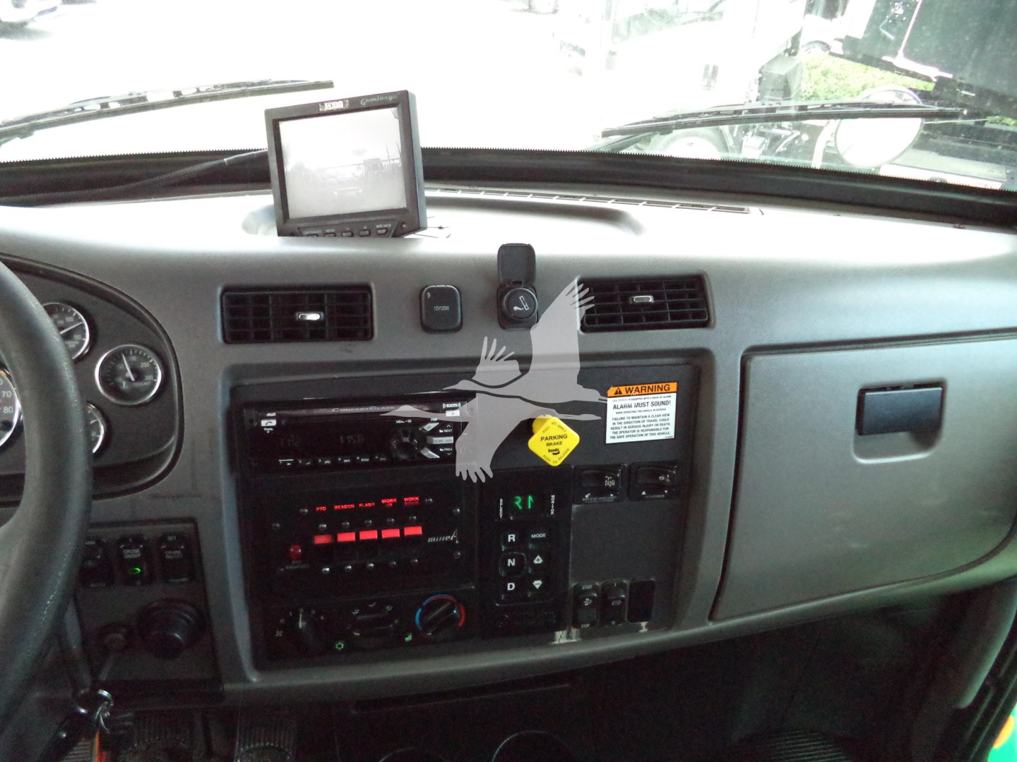 Peterbilt 348 dash and center console showing radio, climate controls, and a GPS unit mounted on top of dashboard.