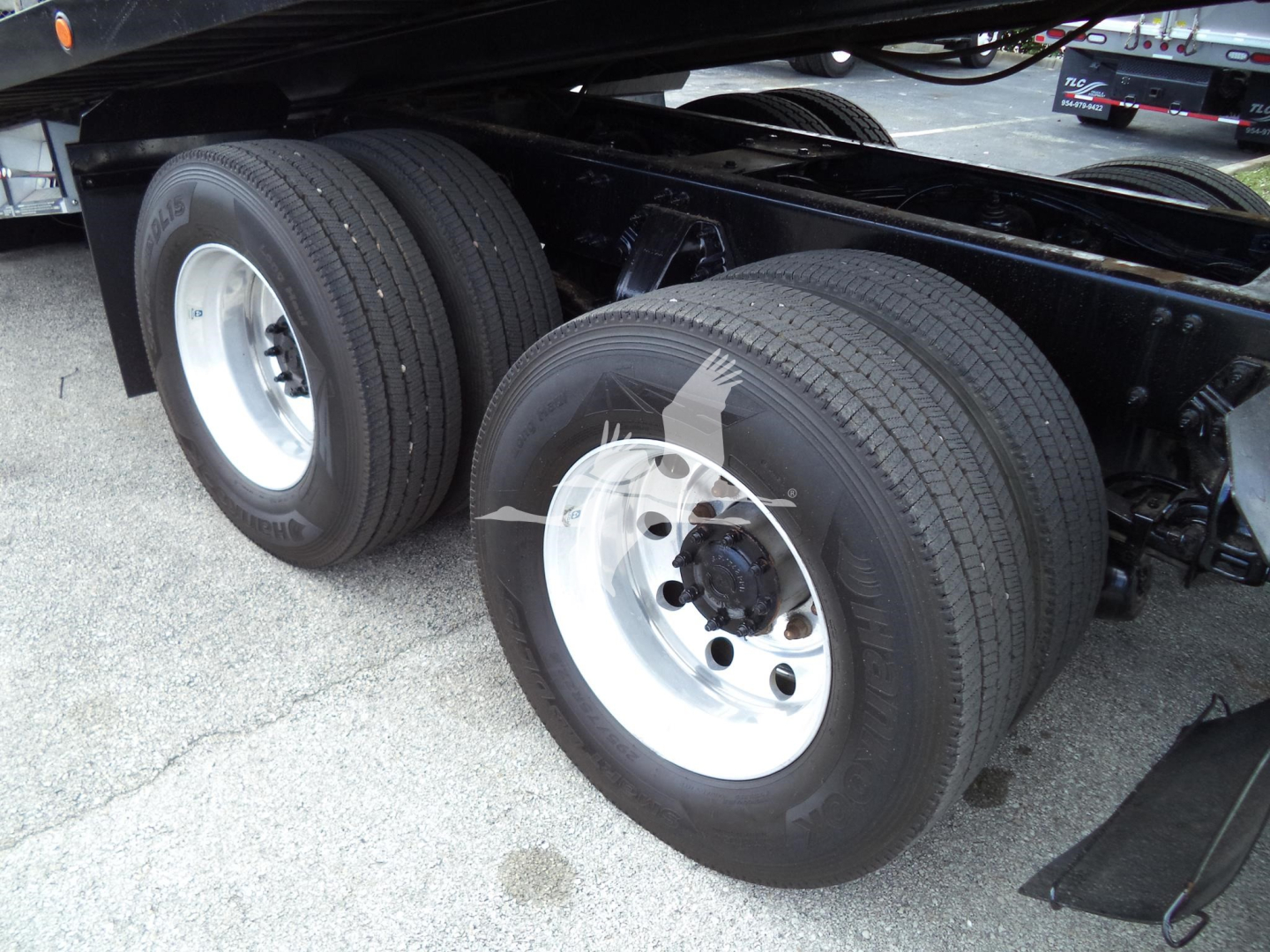 Dual rear truck wheels and frame of a 2016 Peterbilt 348 rollback showing dual tires and silver wheels.
