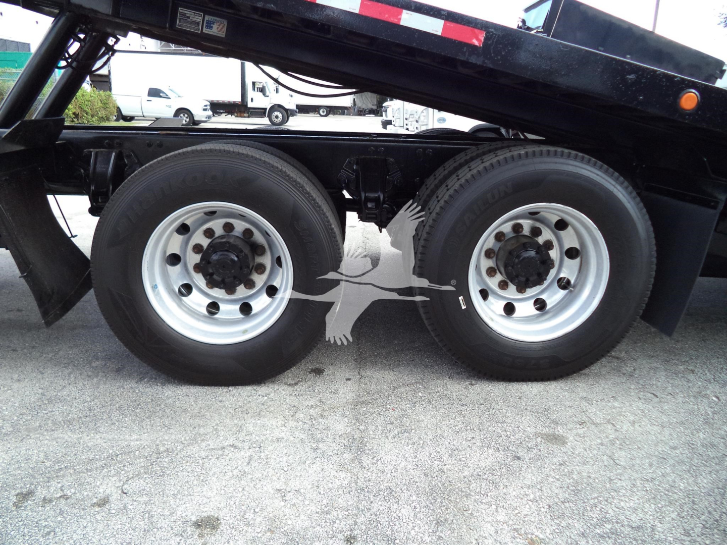 Peterbilt 348 rear dual-drive tires on a rollback truck chassis with wheel hubs and part of the dump bed frame visible.