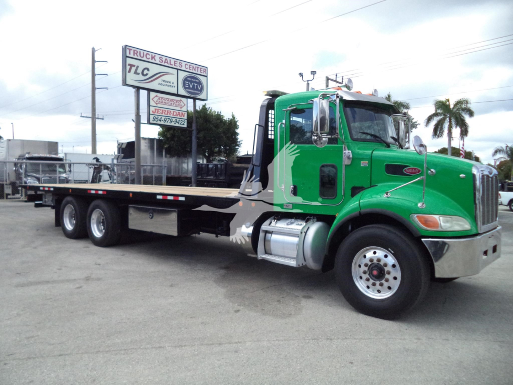 Peterbilt 348 rollback truck with green cab and flatbed, side view showing cab details and wheels.