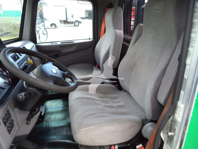 Truck cab interior of a 2016 Peterbilt 348 showing driver seat and passenger seat, steering wheel, dashboard, and gear area.