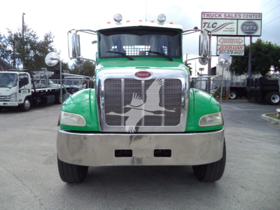 Peterbilt 348 truck front view in green with chrome grille and bumper, stock photo at dealership lot.