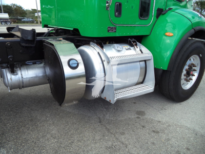 Peterbilt 348 cab side and chrome fuel tank/step area with green cab, side view showing metal fuel tank and exhaust housing.