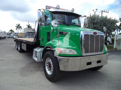 Green Peterbilt 348 rollback truck showing front grille and chrome bumper