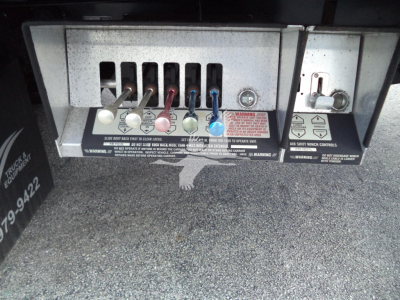 Peterbilt 348 rear electrical panel with multiple colored connectors and warning labels visible; series of levers and plugs under dashboard area.