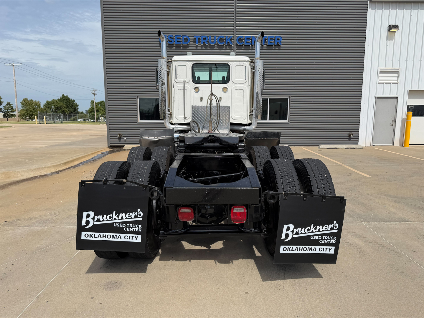 Rear view of a white 2019 Western Star 4900 SF tractor cab showing the chassis and dual rear axles with mudflaps labeled Bruckner's Used Truck Center Oklahoma City.