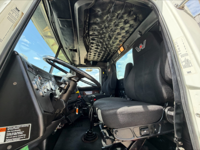 Truck cab interior showing steering wheel, dashboard, and seat with quilted overhead lining; driver side view inside a 2019 Western Star 4900 SF.
