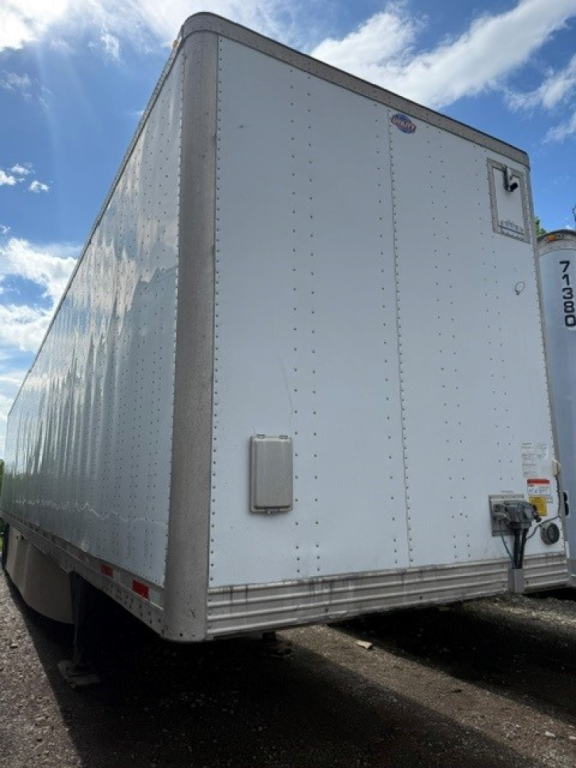 Trailer rear/side of a 2016 Utility 4000DX box trailer showing exterior riveted aluminum walls and rear access area.