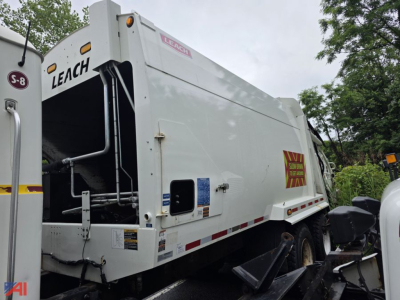 Mack Granite garbage truck rear and side view showing Leach rear loader compactor and warning decals in a used truck listing.