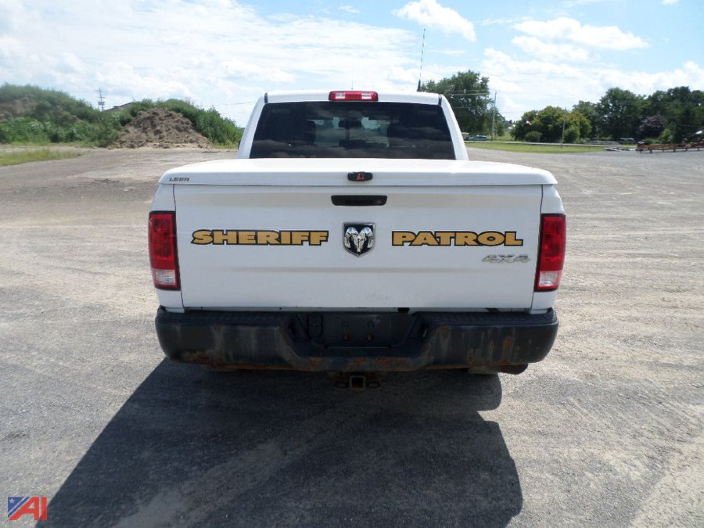 Rear view of a white RAM pickup truck with Sheriff Patrol decals on the tailgate, showing Ram badge and bumper area.