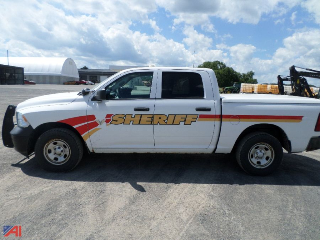 Ram 1500 crew cab pickup truck with sheriff graphics on side panel, side view showing driver door and extended cab.