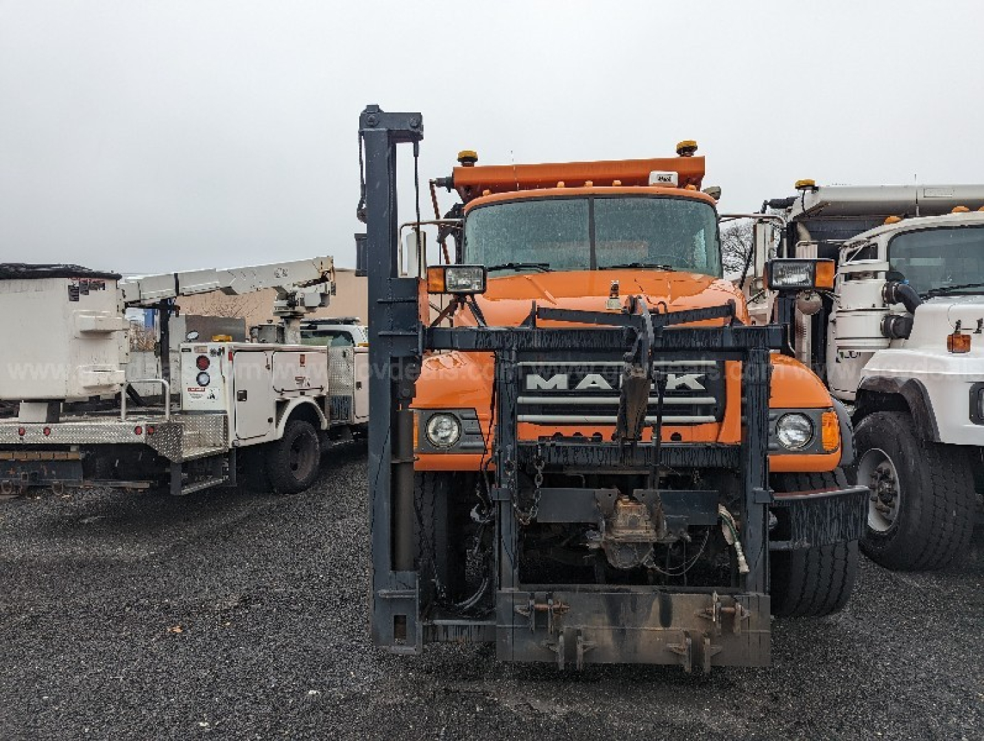 Mack CV713 Granite plow truck front view showing large blade and mounting hardware.