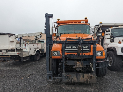 Mack CV713 Granite plow truck front view showing large blade and mounting hardware.