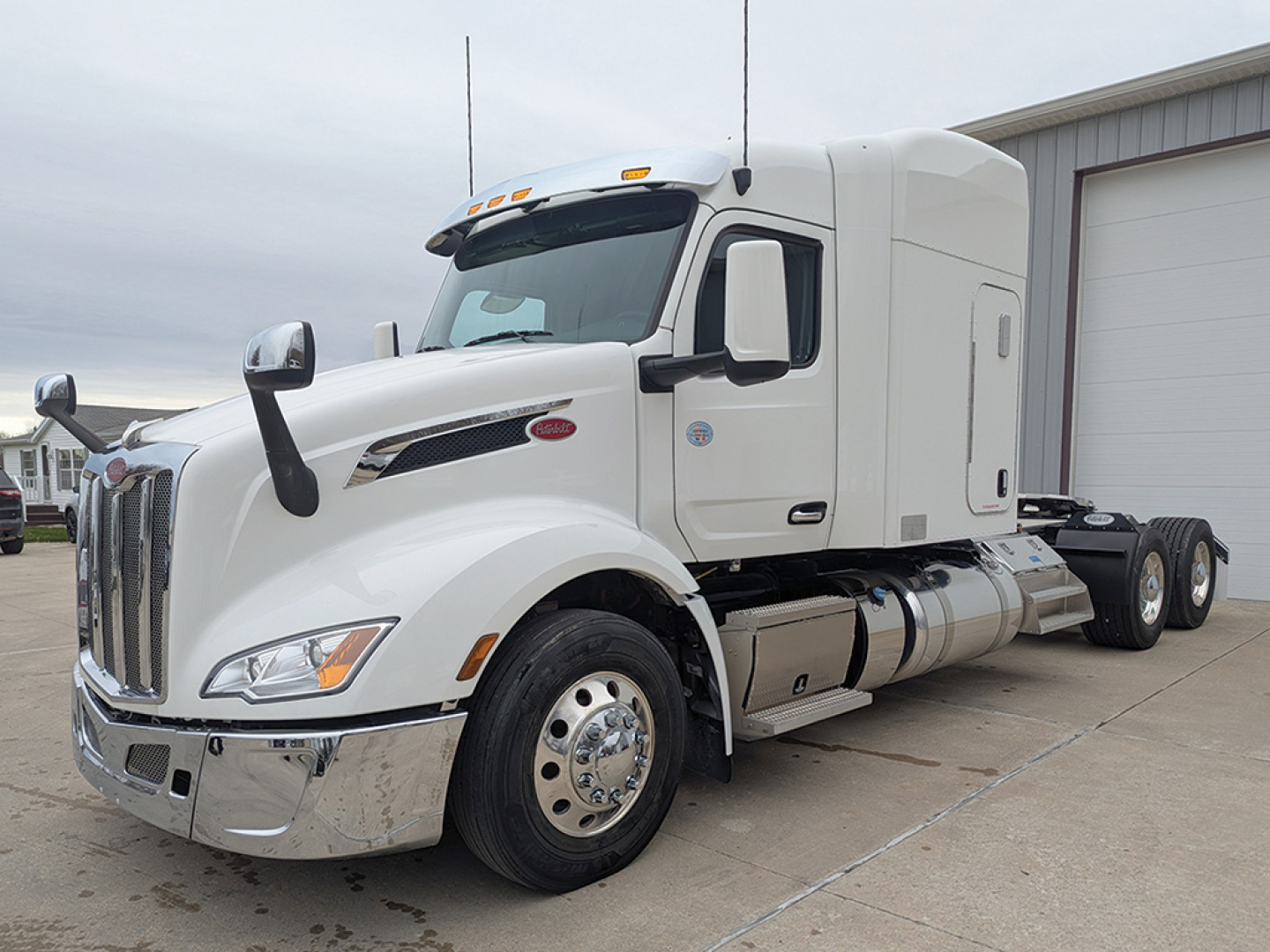 Peterbilt 579 UltraCab tractor truck side view showing chrome front bumper, fuel tanks, and sleeper cab.