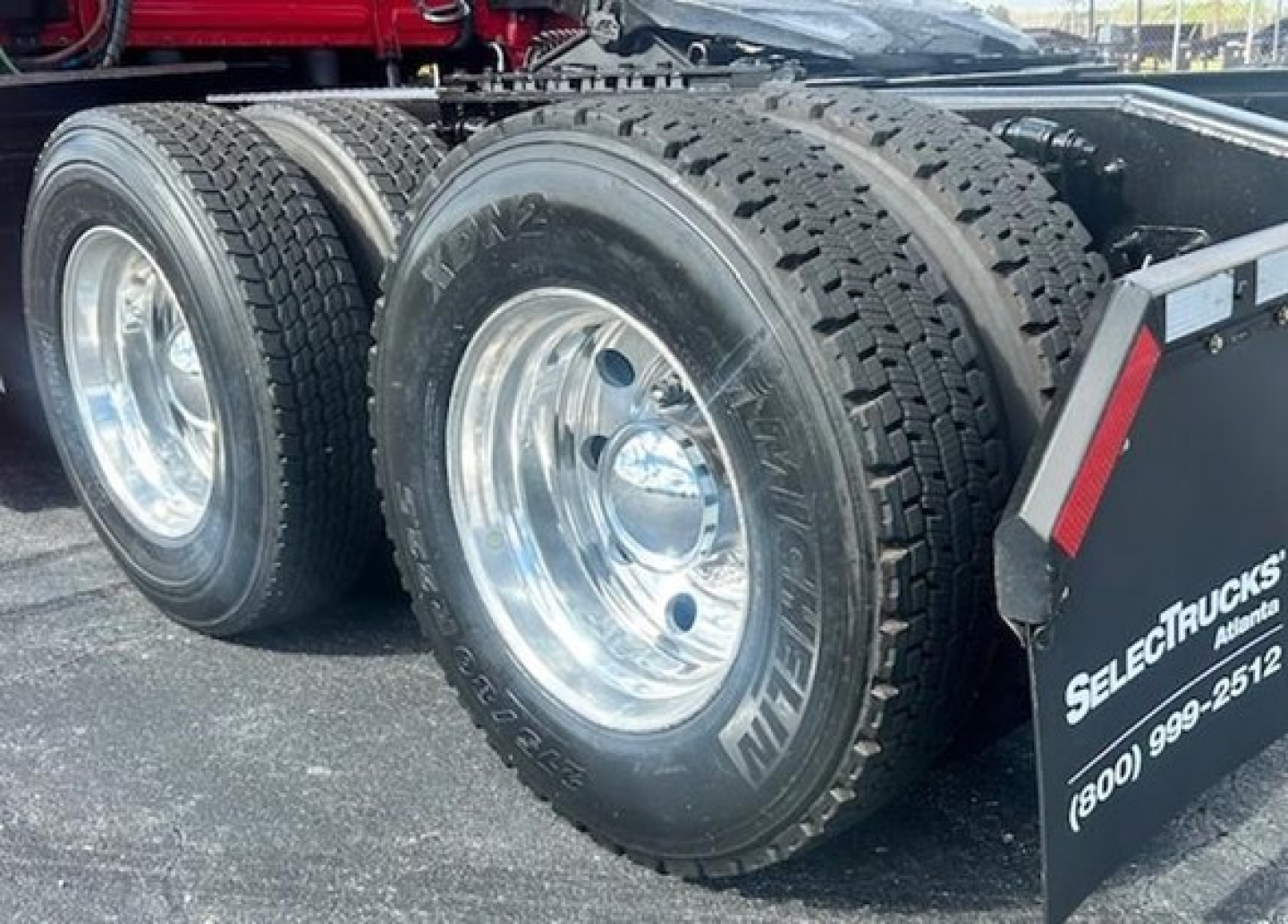 Dual rear truck wheels with chrome rims and heavy-duty tires on a Freightliner Cascadia sleeper tractor chassis.