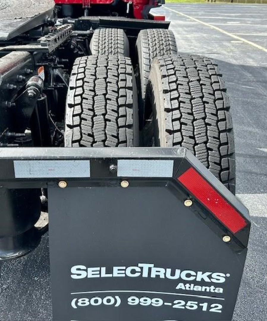 Trailer view of a Freightliner Cascadia 126 rear with dual rear axles and truck bed; visible are tires, chassis, and a SelectTrucks Atlanta plate with phone number.
