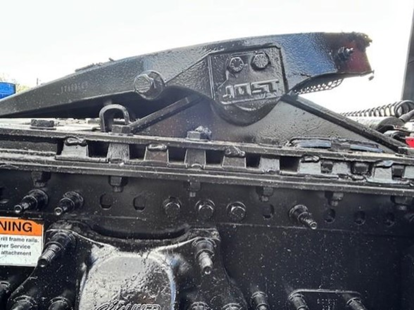 Sheet of truck frame and mounting hardware with Freightliner/Meritor stamp and bolt pattern visible in engine bay area.