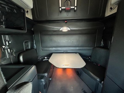 Freightliner Cascadia 126 interior sleeper cabin showing table and seating area with storage compartments.