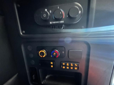 Cab interior panel of a Freightliner Cascadia showing climate controls and auxiliary switches in view