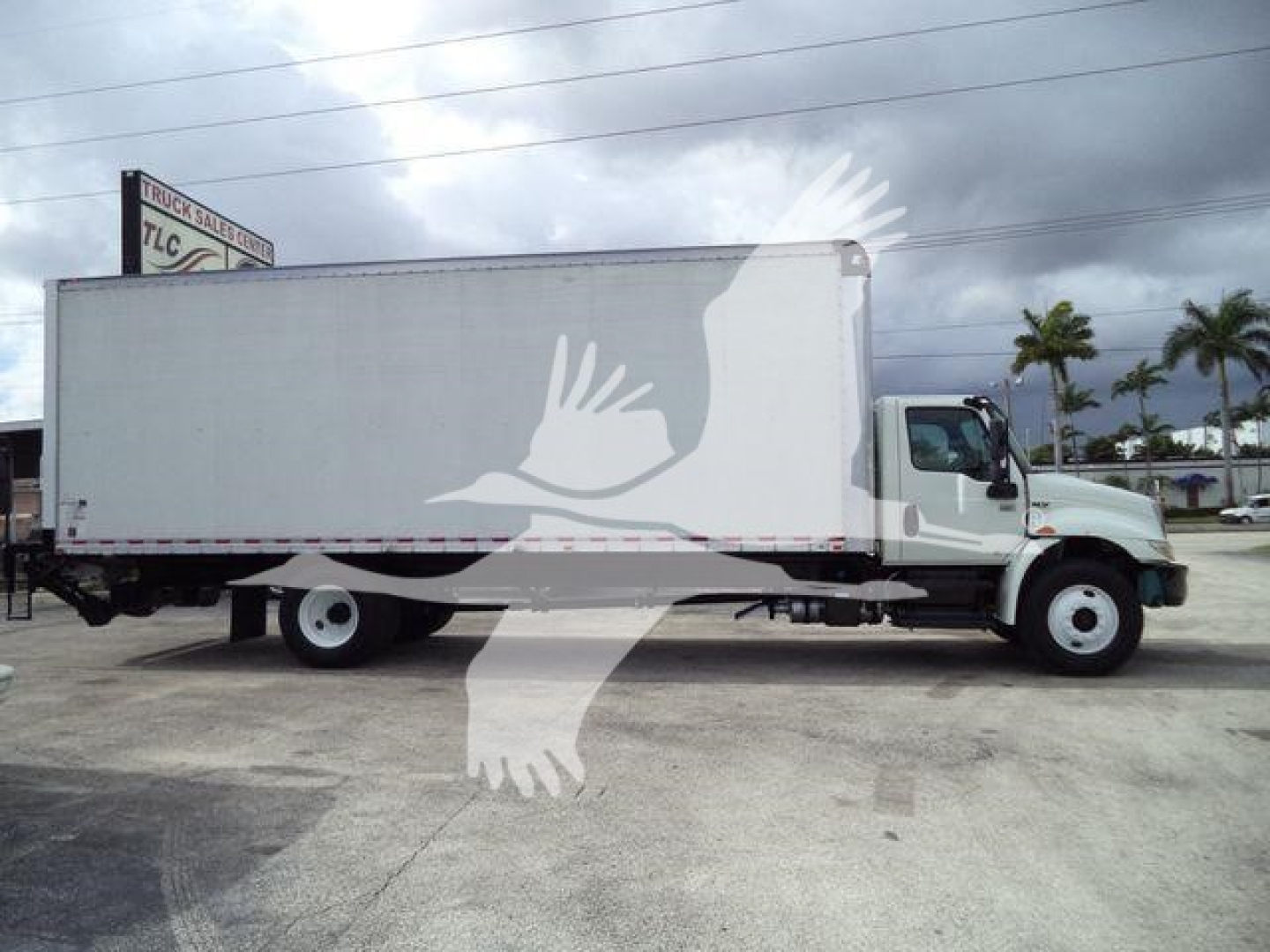 Box truck side view showing large white cargo box attached to cab chassis with black undercarriage and dual rear wheels.