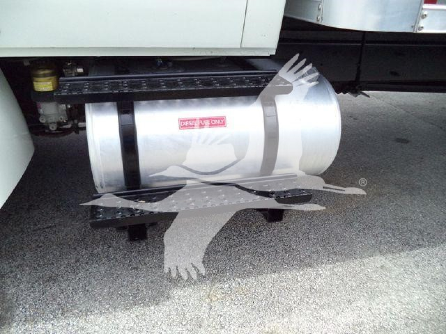 Box truck fuel tank or cylindrical component mounted under the chassis with safety rails and steps.