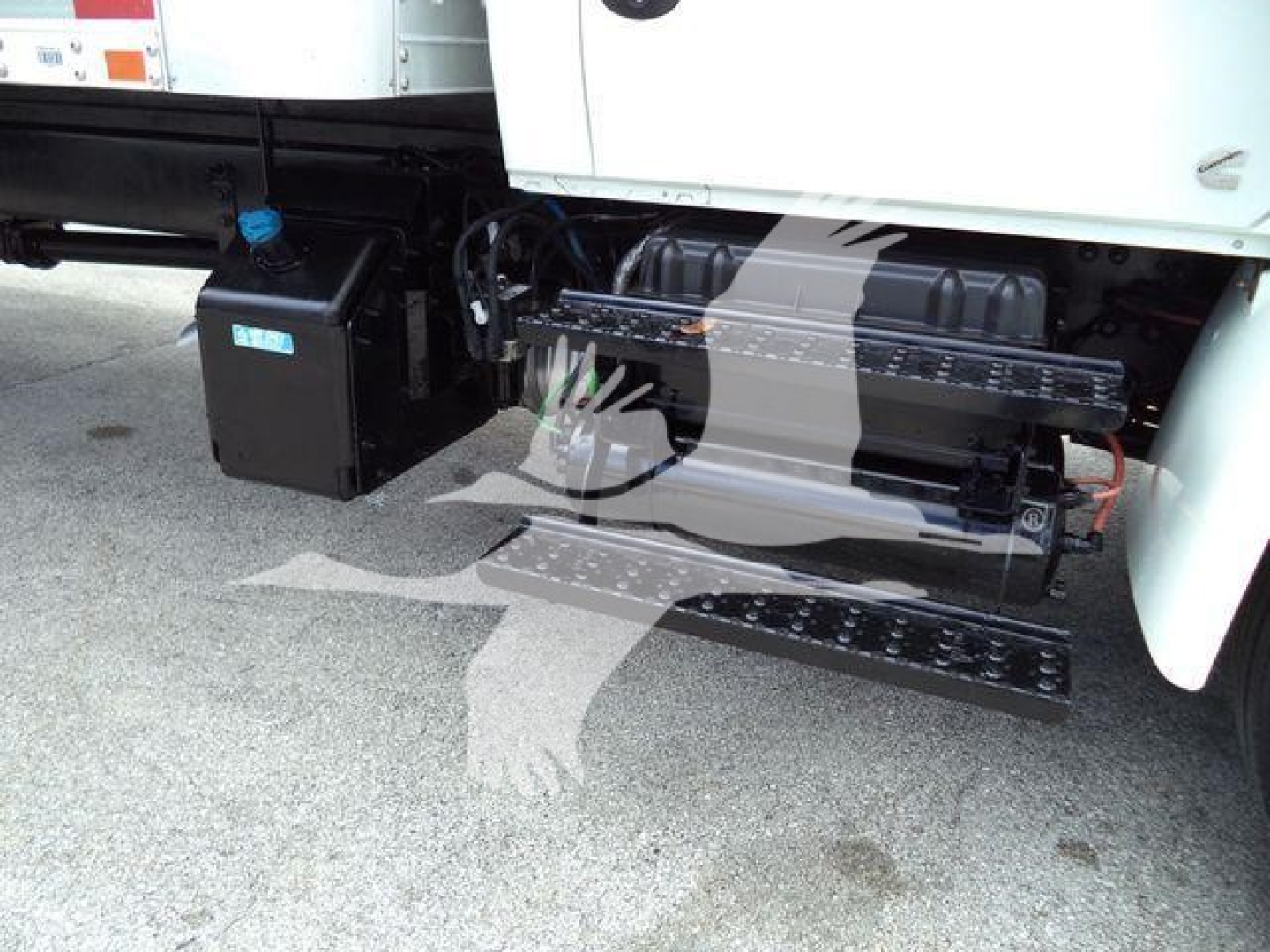 Truck side view showing fuel tank, battery box, and step/ladder attached under the cab on a 2020 International MV box truck.