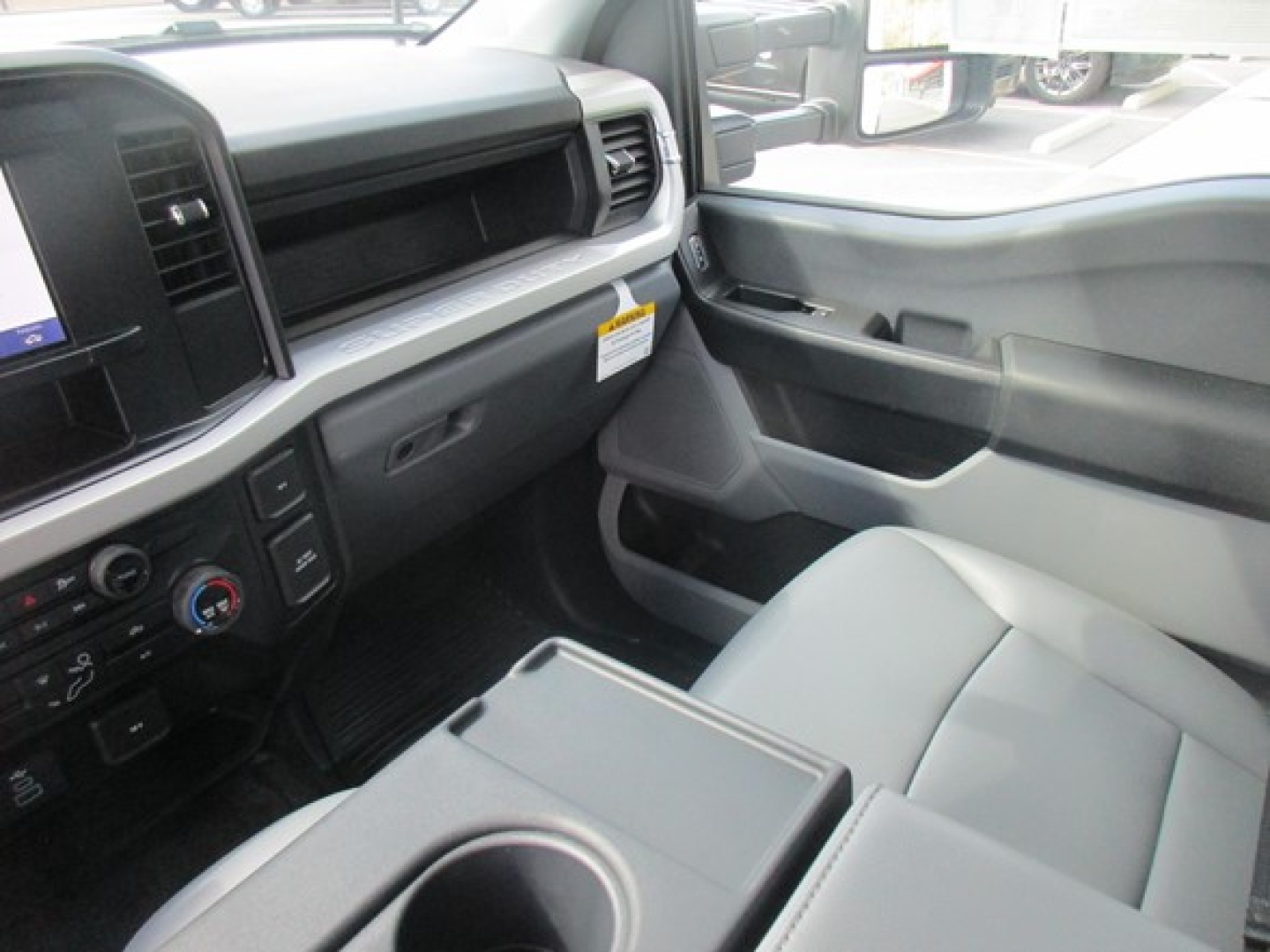 Ford F-550 service utility truck interior view showing front passenger seat, center console with cup holder, dashboard controls, and door panel.