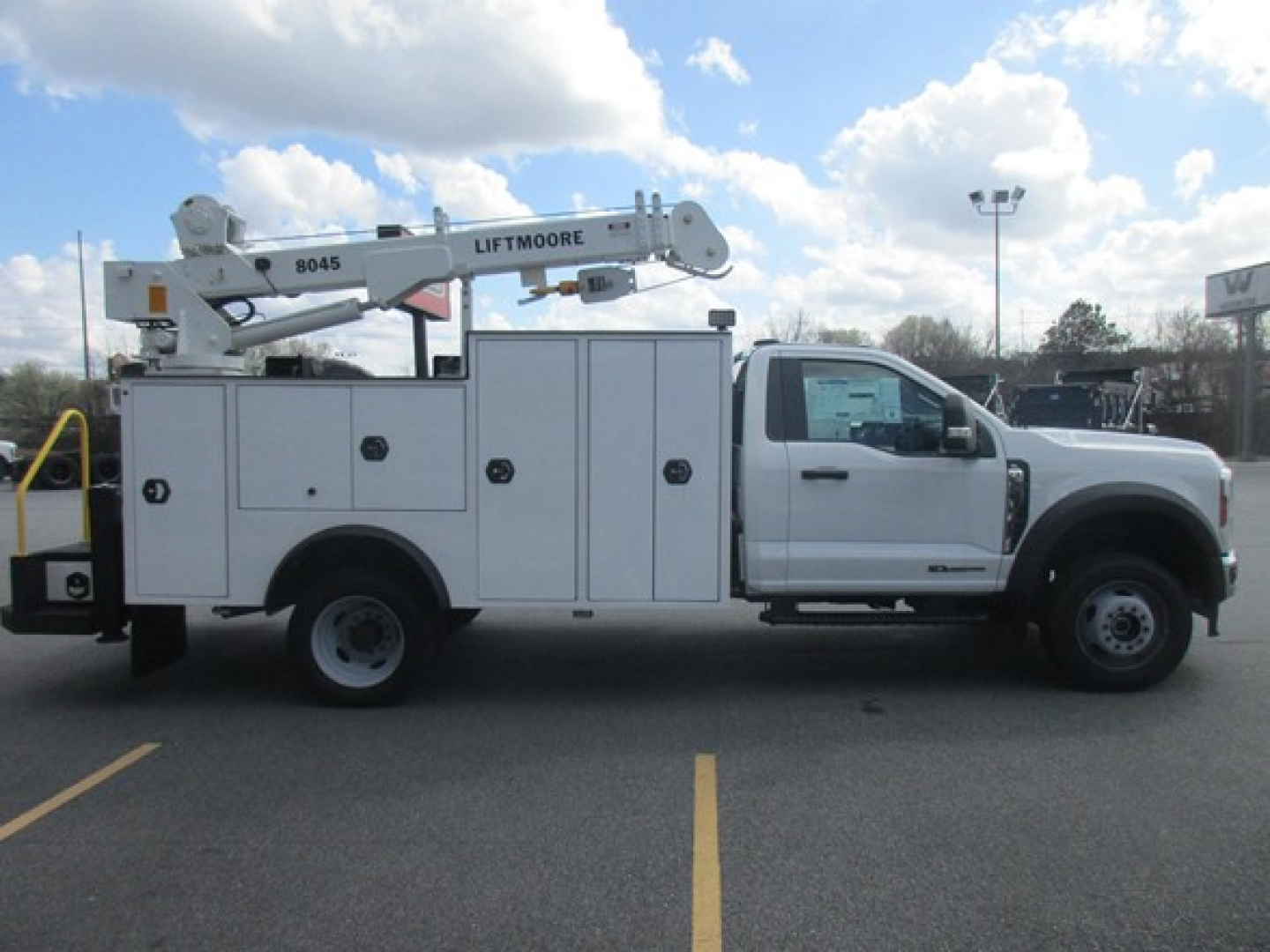 Ford F-550 service body truck with Liftmoore crane, side view showing utility compartments and crane boom labeled Liftmoore 8045.