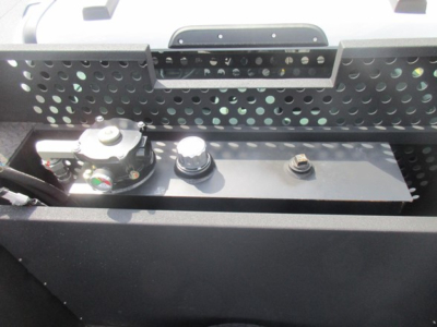 Ford F-550 service/utility truck battery area showing battery hold-down, terminals, and utility rack.