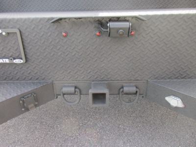 Ford F-550 service/utility truck rear view showing Diamond plate bed, hitch receiver, and tow hooks with metal latch.
