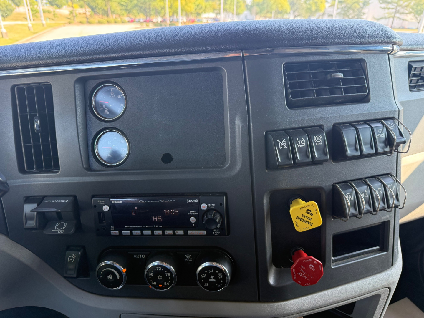Peterbilt 579 dash and center console showing gauges, switches, and a red/green/yellow controls area; images include HVAC controls, radio unit, and ignition/key switch area.