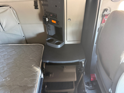 Cab interior of a 2022 Peterbilt 579 showing seating area and center console with cup holders and control panel