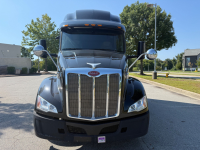 Peterbilt 579 truck front view showing large chrome grille with Peterbilt emblem, headlights, and mirrors.