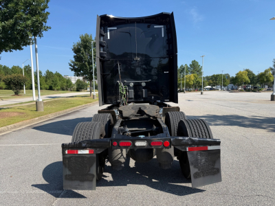 Peterbilt 579 tractor rear view showing chassis and dual rear axles, fifth wheel area, mud flaps, taillights, and U-shaped exhaust under sleeper cab.