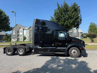 Peterbilt 579 tractor in profile showing cab, fuel tanks, and rear wheels; no legible text visible on the truck from this view.