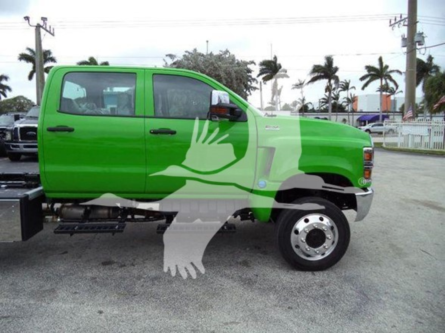 Green 2023 International CV truck side view showing crew cab with extended mirror and black running boards.