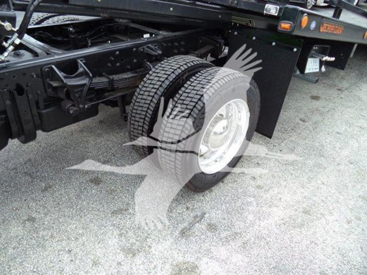 Truck chassis and dual rear wheels of a new 2023 International CV rollback truck showing tire and wheel assembly.