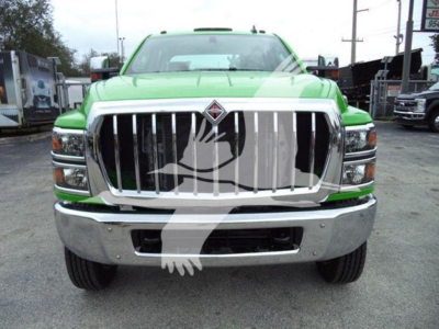 Front view of a bright green 2023 International CV rollback truck with a large chrome grille and bumper.
