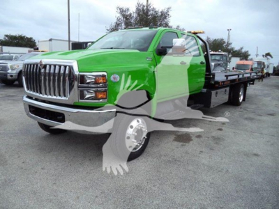 Green and gray International CV rollback truck showing front grille and flatbed
