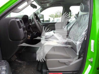 Interior of green 2023 International CV rollback truck showing front seats and dashboard, plastic seat covers in place.