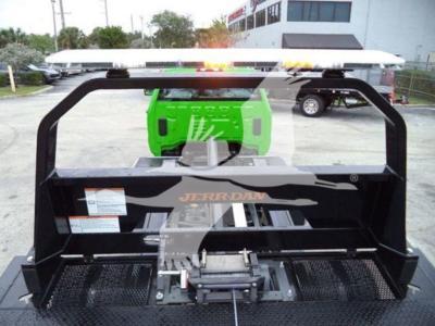 Engineering equipment showing Jerr-Dan rollout with green hydraulic unit and black platform for a rollback truck bay.