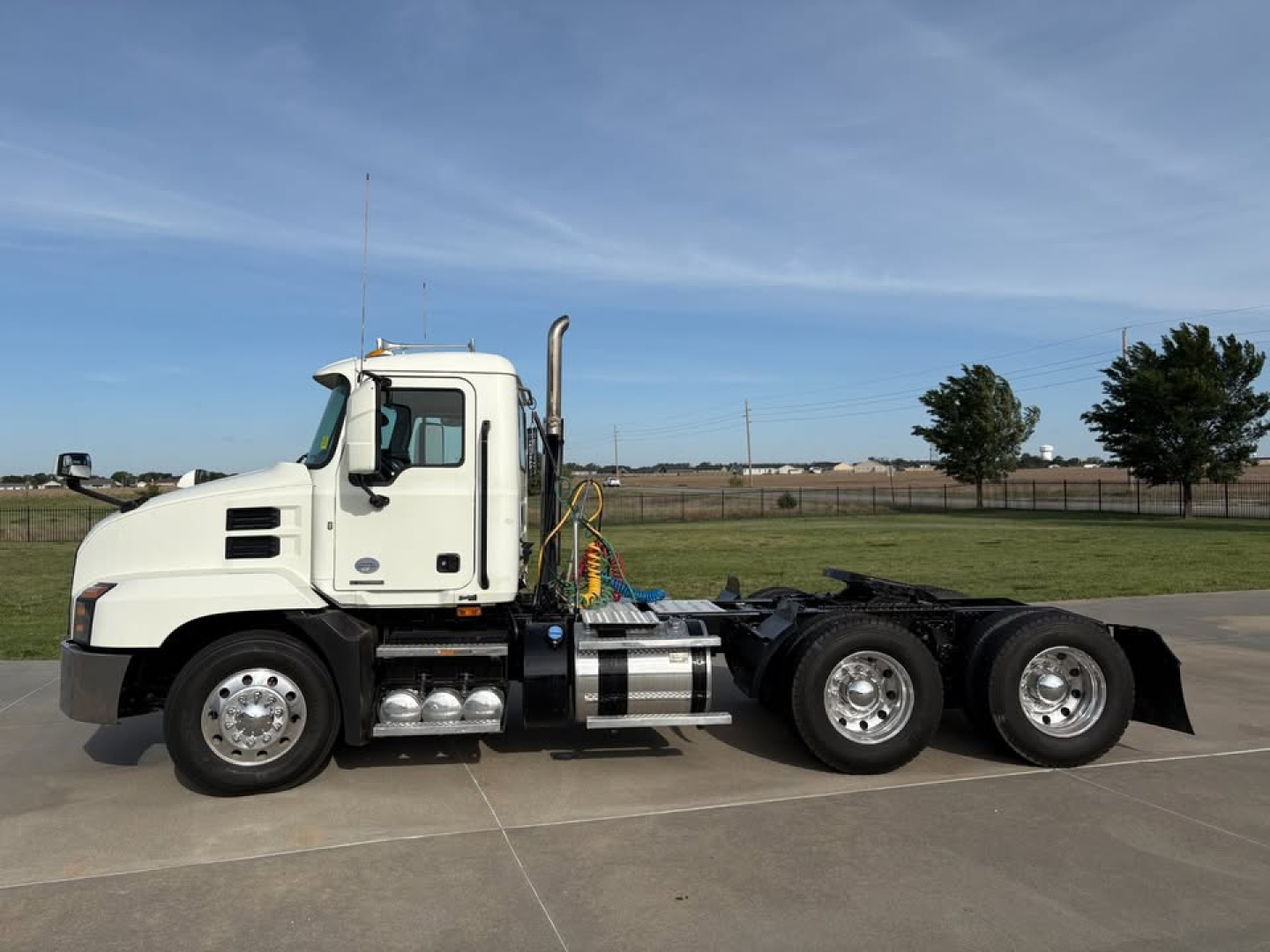 Tractor unit in profile view showing white 2019 Mack Anthem day cab with chassis and rear dual-axle configuration.