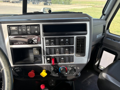 Dashboard and control panel of a 2019 Mack Anthem conventional daycab showing gear shifter, switch panel, and climate controls.