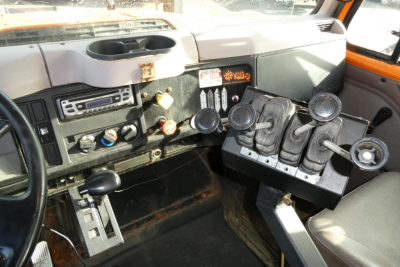 Interior of truck cab showing gear shifter and multiple control levers in the dash area.