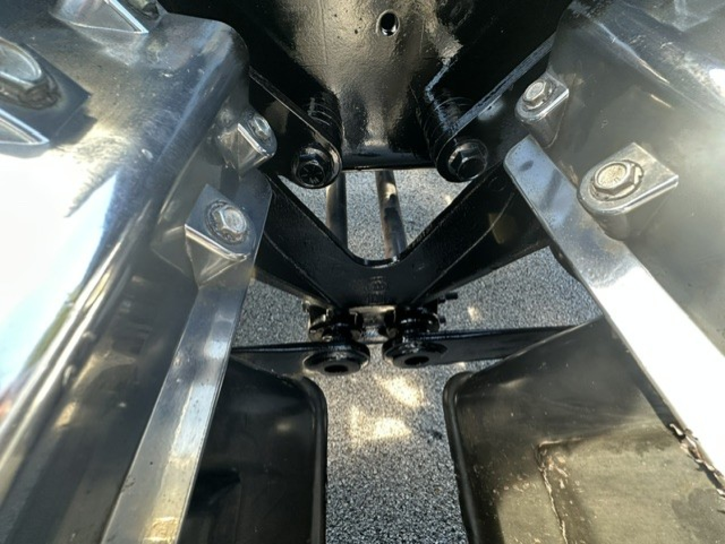Kenworth T880 chassis area showing front hitch/tow hitch and suspension mounting points with metal brackets and bolts.