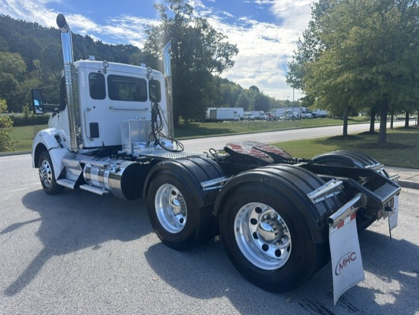 Kenworth T880 conventional daycab tractor rear and side view showing dual rear axles and chrome exhaust stacks