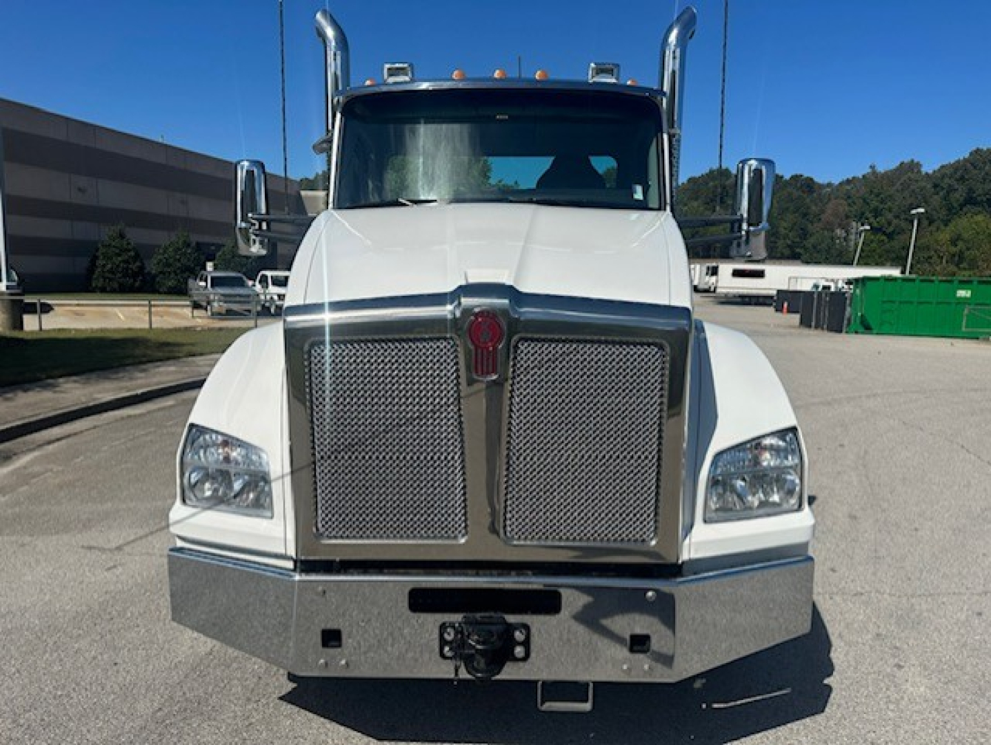 Kenworth T880 front view showing large chrome grille, dual air intakes, square headlights, and heavy-duty bumper. License plate area and hitch visible.