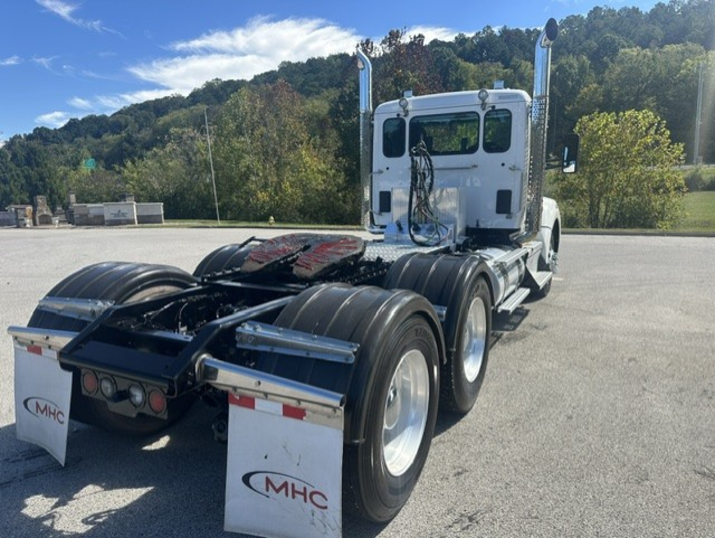 Kenworth T880 tractor with cab and rear axle, showing fifth wheel and dual rear tires. Visible text on mud flaps: MHC. No other legible labels or numbers.